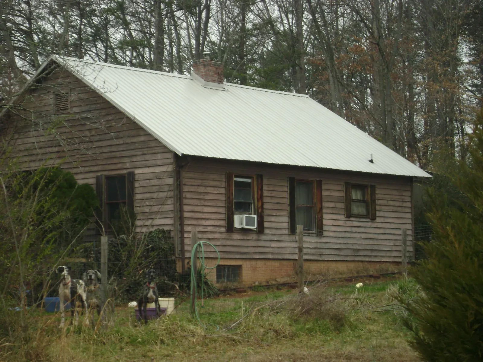 White metal roof on an old wood sided farmhouse, from a Metal Roof Installation job in Smithville